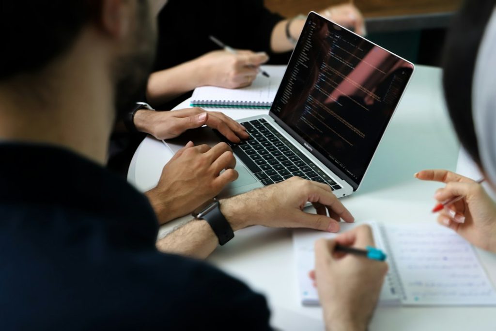 Business professionals collaborating around a laptop during a strategy planning meeting