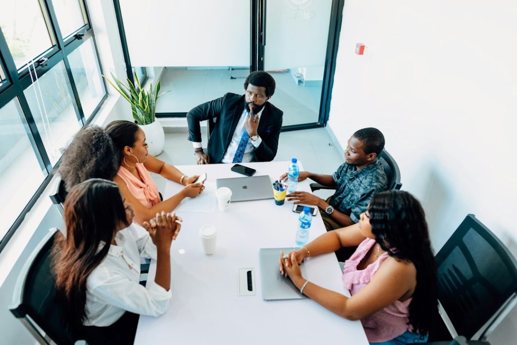 Black business professionals discuss leadership and strategy around a conference table